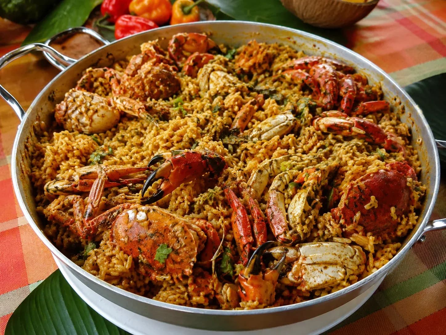 Riz doré aux épices créoles couvert de crabes de terre rouges entiers et d'herbes fraîches dans une poêle